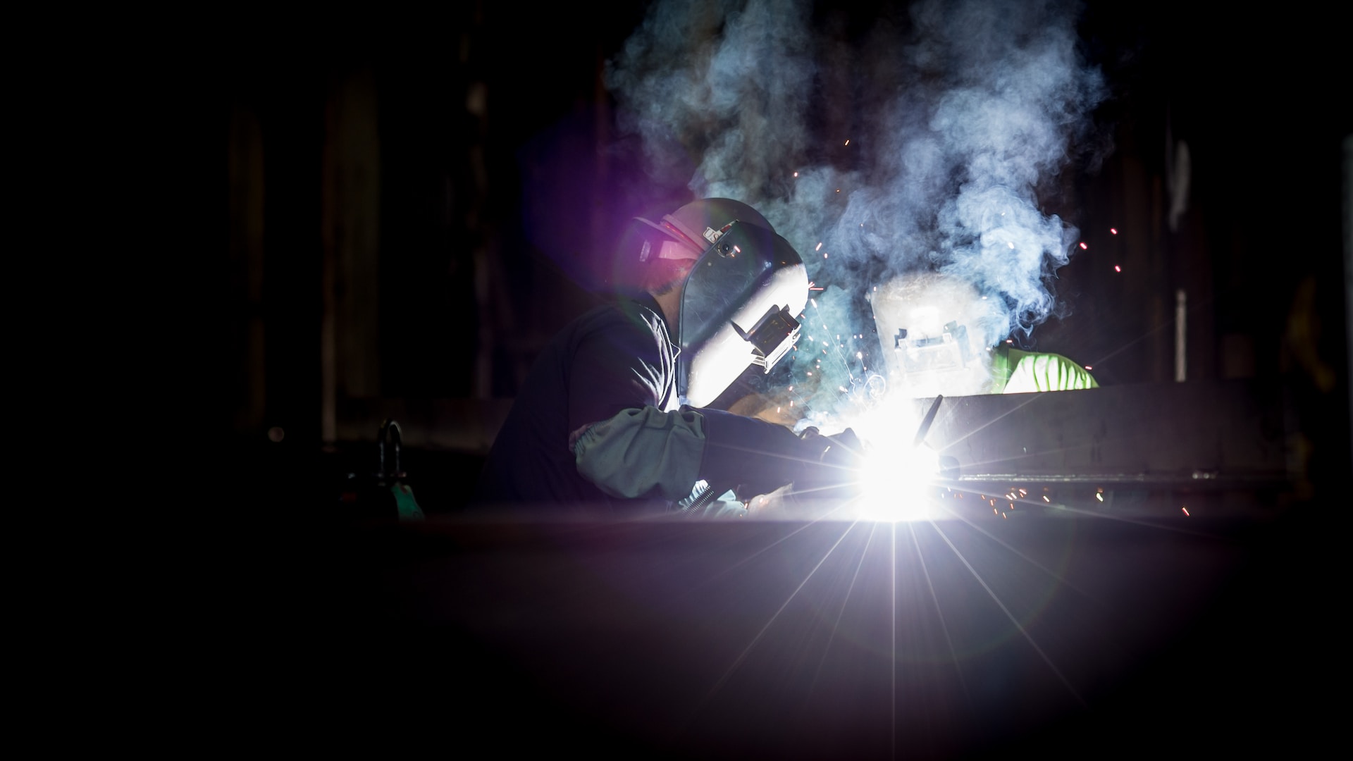 person welding metal using gray helmet